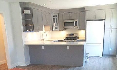 Barstool seating with a beautiful quartz countertop. The kitchen boasts a gorgeous open floor plan.