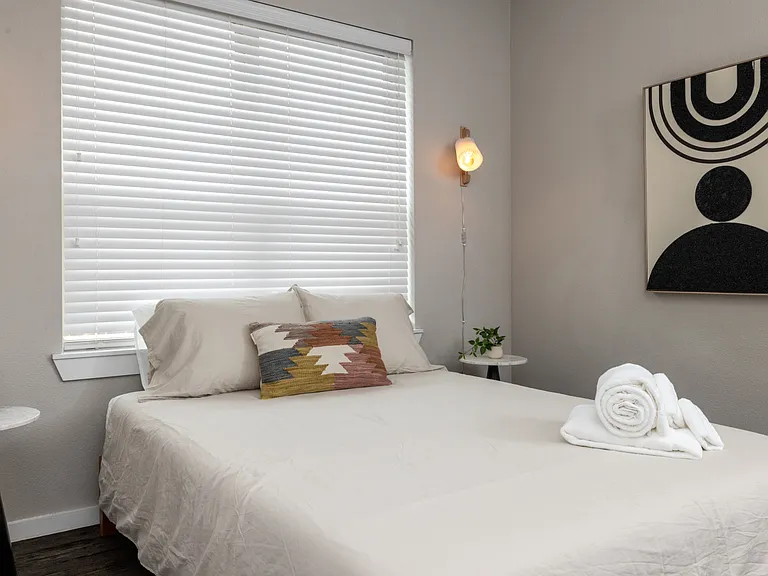 Inviting fourth bedroom with a queen bed and soft hanging lights on each side_simple, stylish, and made for a peaceful night's sleep. This bedroom is located upstairs.