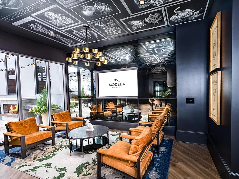 Settle into the lounge at Modera Old Ivy, where layered textures, fireside comfort, and intimate seating create a cinematic escape.