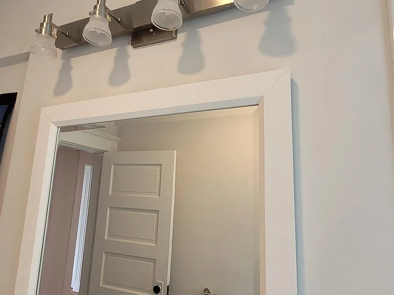Mirror and brushed nickel light fixture