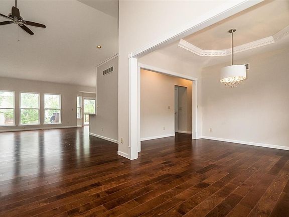 A view from the entry shows the flow of the entertainment areas on the Main Level.  The Dining Room offers a sculptural tray ceiling with Designer Lighting.
