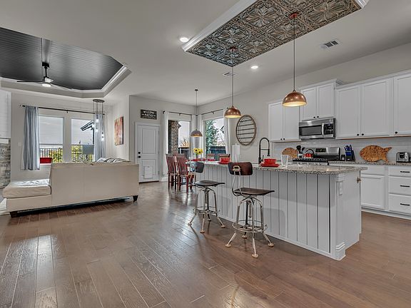 View of the kitchen looking towards the rear of the house, with a dining table for 6, and a back door (accompanied by a doggie door) leading to a covered, ground-level deck and offering lake views.