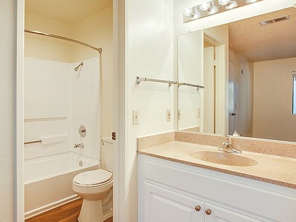 Your bathroom includes a vanity and curved shower rod