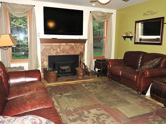 Living room has an inviting fireplace and wood floors.
