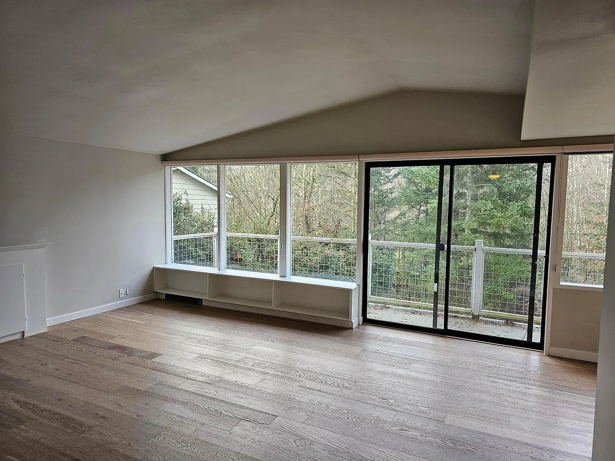 Photo 2 of 24 - 5521 25th Ave NE #TOP FLOOR - Seattle, WA Living room with vaulted ceilings, wall of windows that looks out on to Ravenna Park, brand new engineered hardwood floors! Sliding doors open to deck! - 5521 25th Ave NE #TOP FLOOR