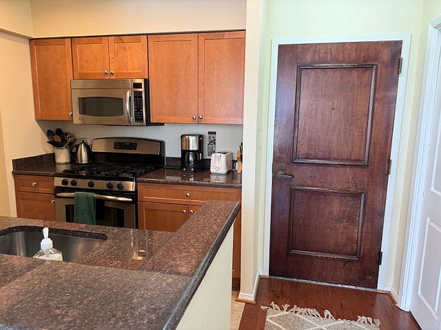 Front entrance to unit with open kitchen. Stainless steel appliances.