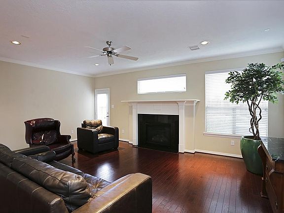 Living area with warm neutral colors, gas log fireplace and hardwood floors
