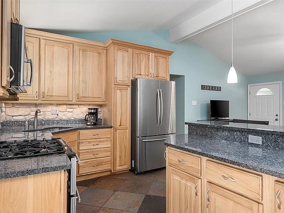 Kitchen offers custom cabinets, granite countertops, gas range, microwave and decorative backsplash.