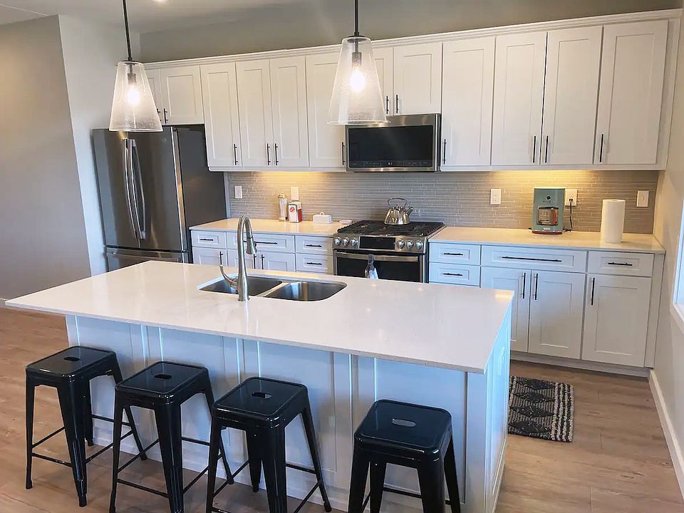 Fully equipped kitchen with new appliances and counter seating at the island and view of the lake.