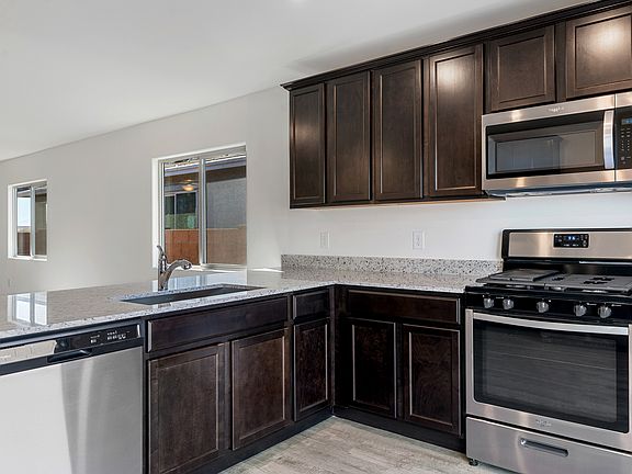 Chef-ready kitchen with espresso cabinets, granite countertops, and stainless appliances.