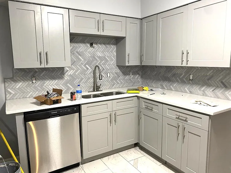 Newer shaker cabinets with quartz countertops and designer backsplash