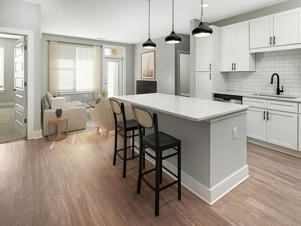 Modern kitchen with white cabinetry, white quartz countertop, stainless steel appliances, and hard surface flooring