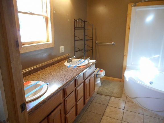 newly remodeled bathroom with double sinks and large corner tub