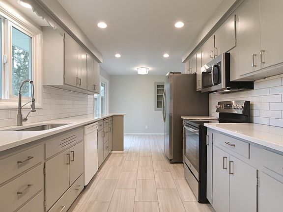 kitchen from mudroom/ laundry area to dining room / eating bar. Features sliding glass door to the large fenced back yard