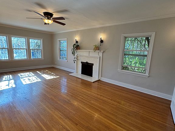 Large living room features a decorative fireplace and original wood and french doors with beveled glass.