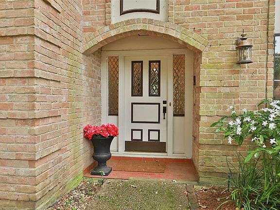 Covered entry has traditional hard wood front door with lead glass inserts.