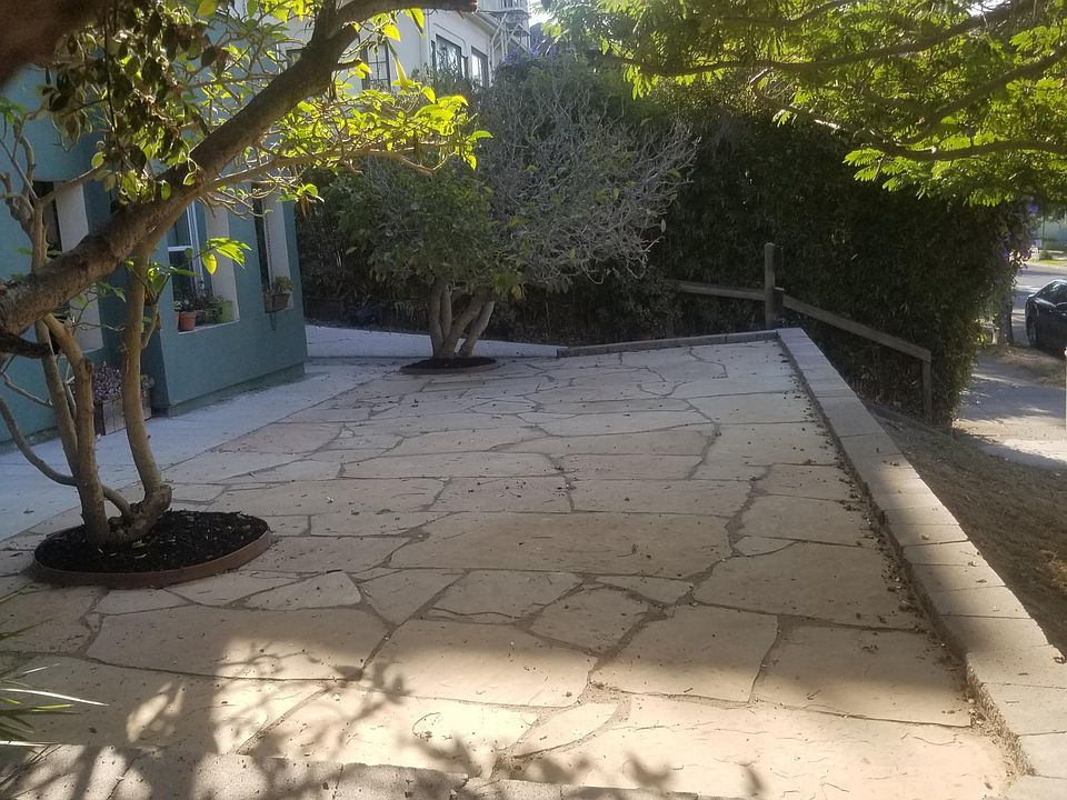 Enter from the outdoor stone patio with magnolia tree and flowering vines.