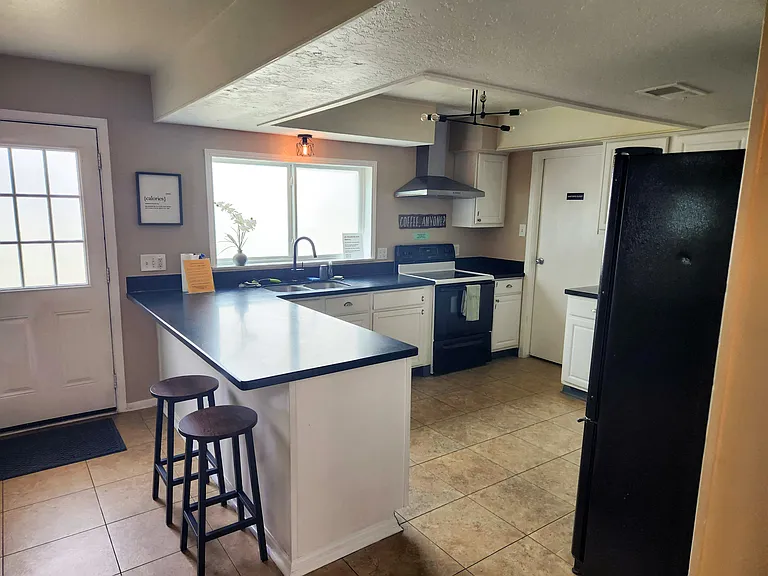Shared kitchen and bar space, two fridges and ample assigned pantry space.
