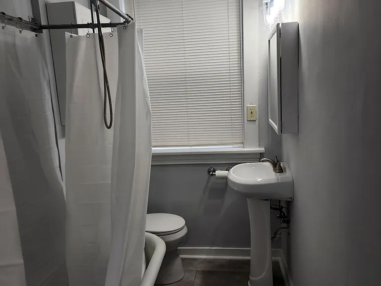 Bathroom with new pedestal sink clawfoot tub / shower combo, new bathroom floor tile.