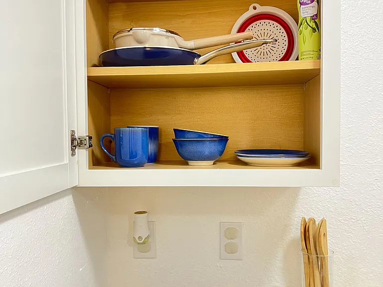Kitchen storage with open shelving and convenient countertop space for meal prep and everyday cooking.