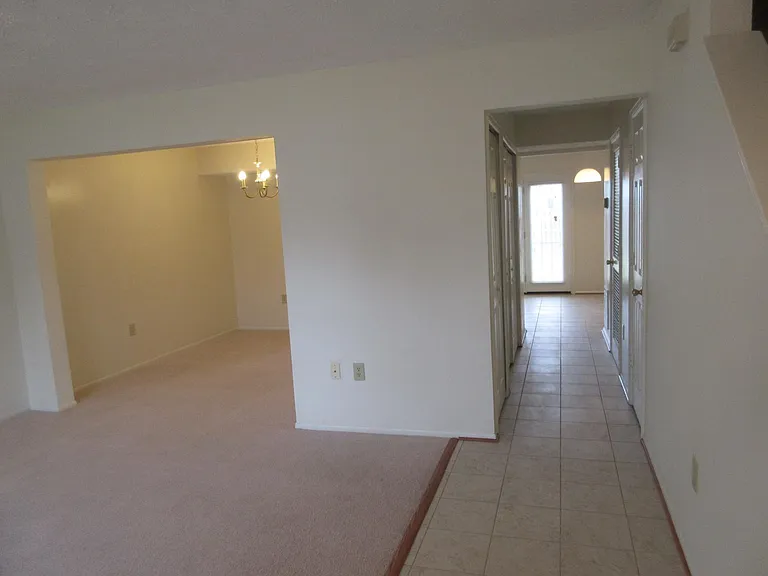 Entry view of living/dining area hallway with washer/dryer, powder room, breakfast nook