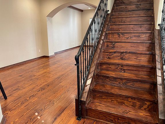 1st floor entryway with pine and wrought iron staircase and WC separate from living/dining area.