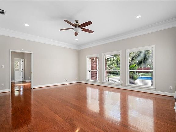 Empty room featuring ornamental molding, wood-type flooring, and ceiling fan
