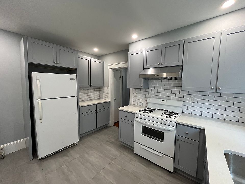 Newly renovated kitchen with new kitchen cabinets, quartz countertops, tile floors and backsplash, new electrical work and plumbing, and recessed lighting