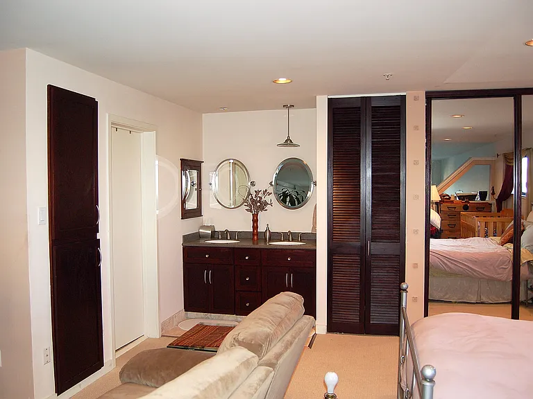 Vanity with dual sinks in bedroom area.