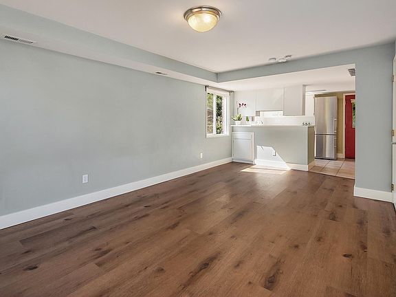 Spacious and bright living room with open floor plan and brand new flooring.