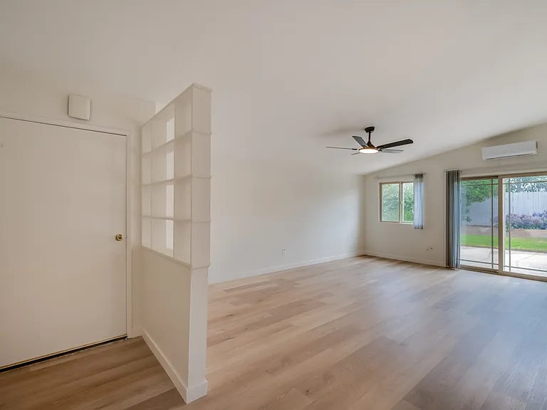 Built-in decorative shelving by front door; ceiling fan and sliding glass door in living room. Brand new mini-split (air conditioning and heating) in living room!