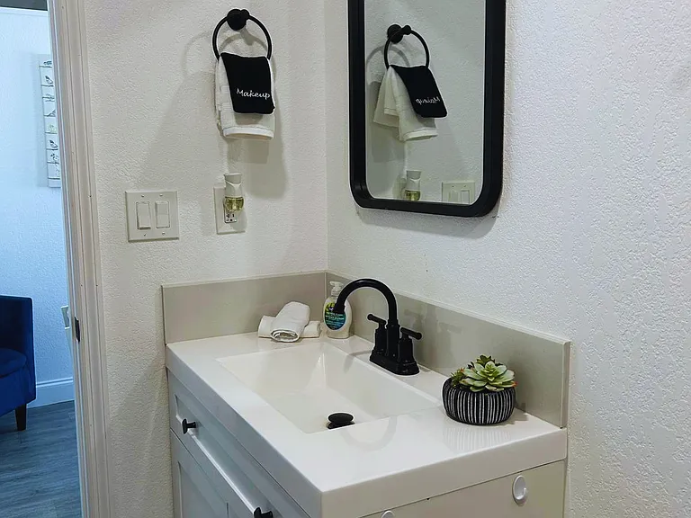 Bathroom featuring towels, mirror and vanity cabinet below.