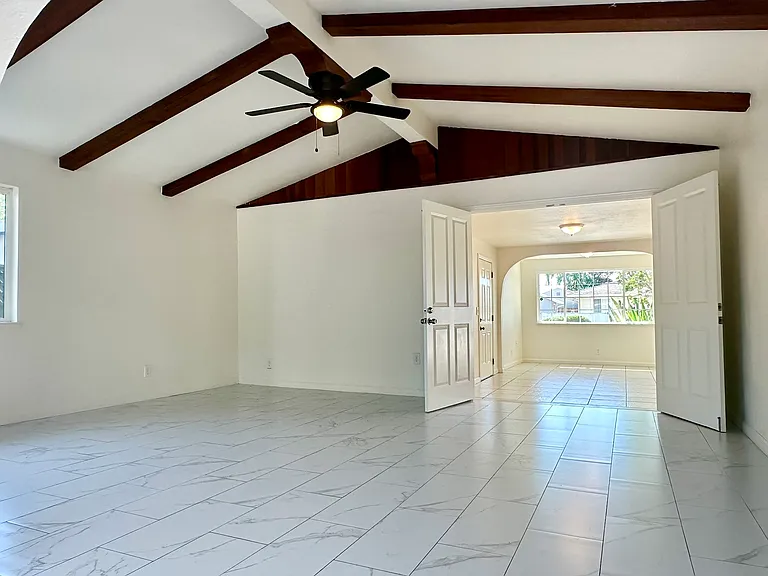 Spacious secondary living area with high ceiling and exposed beams