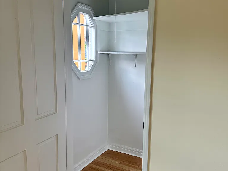 Living area walk-in closet with shelving and sweet window