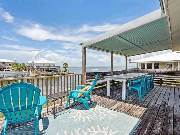 Wooden deck with a water view and outdoor dining space