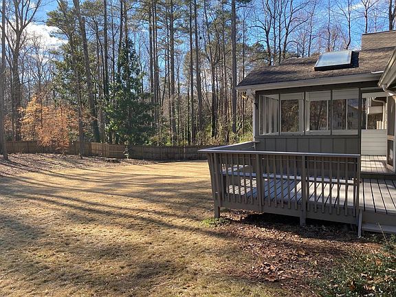 Large flat fenced in backyard with deck and screened in porch