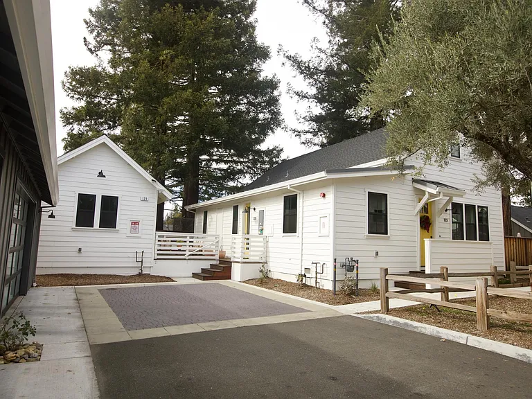 Main building to the right with kitchen, living room, bedroom with en suite bathroom, washer and dryer and 1/2 bath, full deck off back of house with Design within Reach furniture.