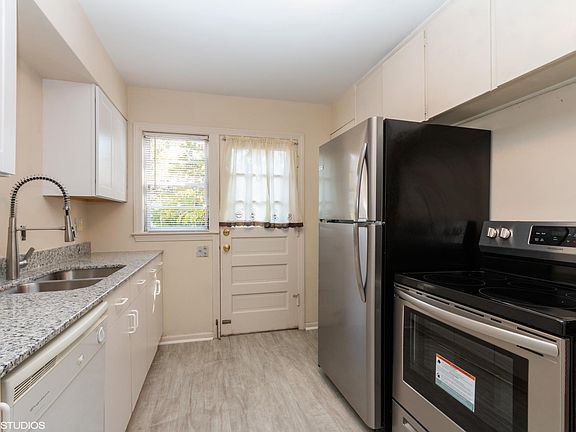 Kitchen, looking toward back door. Note granite counters, and stainless steel appliances