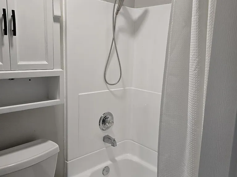 New shower head makes cleaning area easy. Shower curtain provided. Shower and tub areas newly glazed and updated.