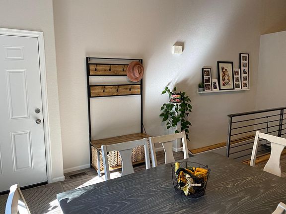 The stairs on the other side of the room lead to a partially finished basement with a workshop/storage room. The door goes to the garage.
