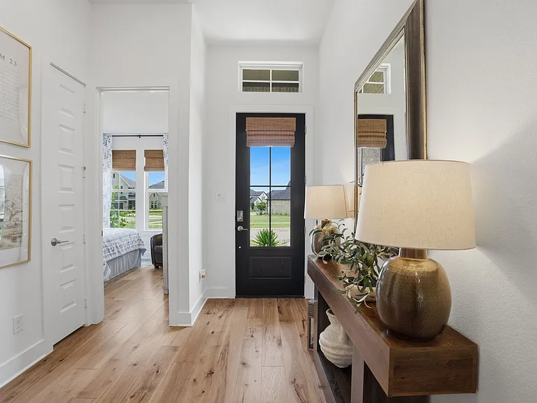 A welcoming foyer boasts high ceilings, a pretty front door + 2 secondary bedrooms split by a shared full bath.