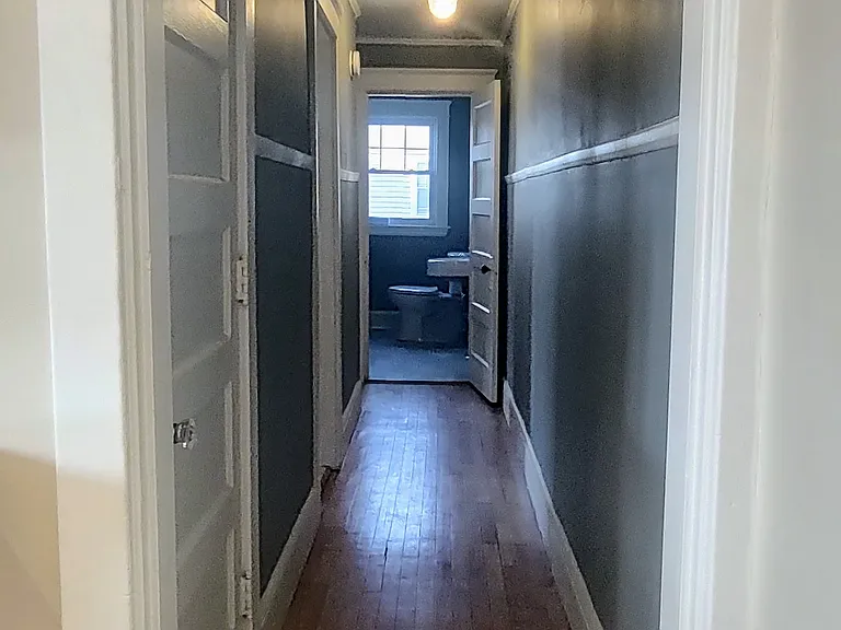 A hallway connects the kitchen to the bedrooms and bathroom. The laundry closet is on the left.
