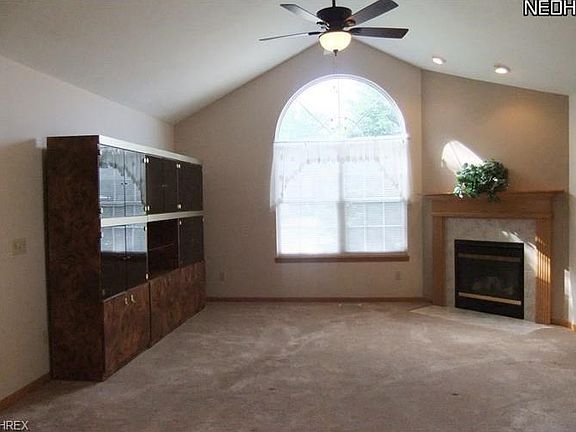 Great Room with Corner Gas Fireplace with Formal Mantle, Fan/Light Kit Plus Oversized Circle Top Window.