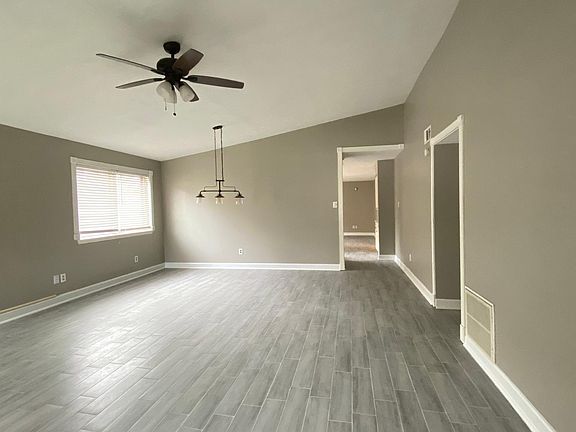 The living room with fireplace opens to the dining room with high ceilings