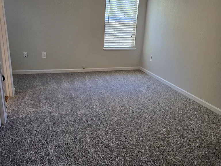The second primary suite is thoughtfully designed with generous living space, plush carpeting, modern finishes, and a private en-suite bathroom.