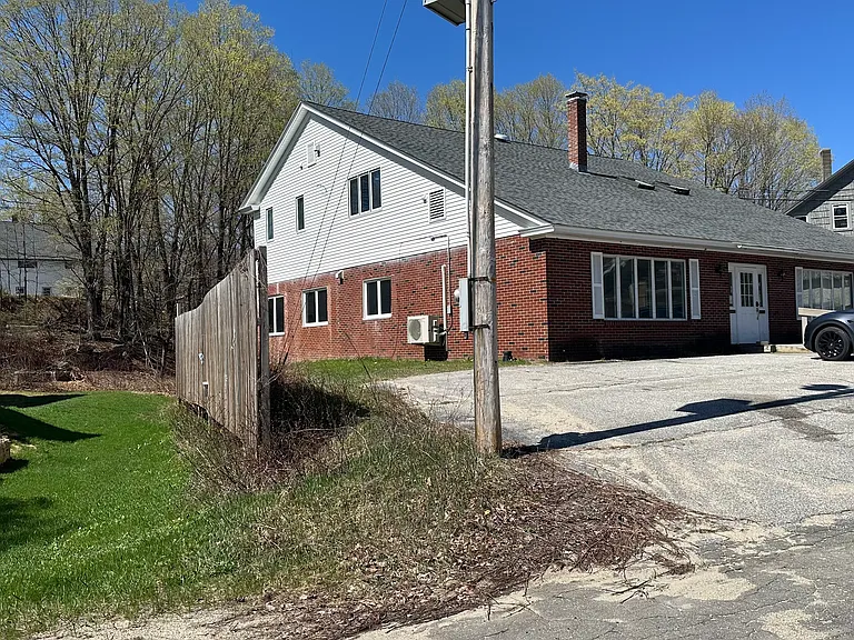 Roadside of building (apartment is the upper level- white sided for this side of building)