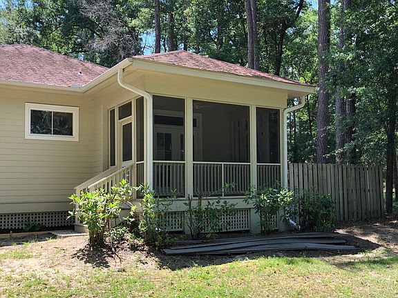 Private screened in side porch w/lake view and 2 side doors_.one opening up into fenced in back yard w/small patio & full size BBQ
