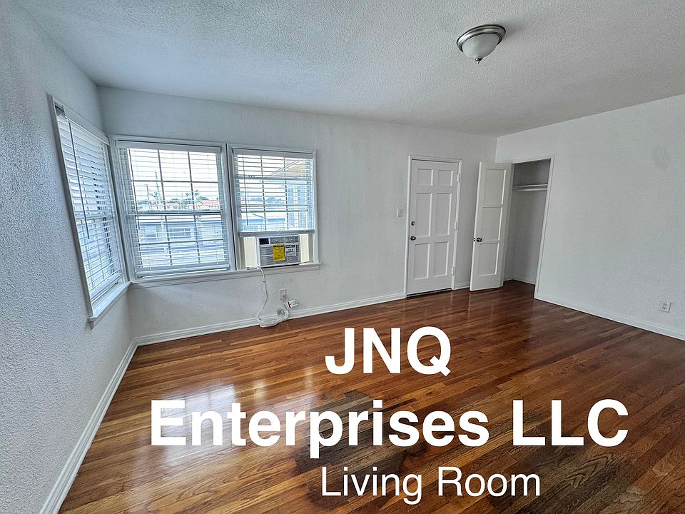 Freshly painted comfortable size living room with new air conditioner and refinished hardwood floors.