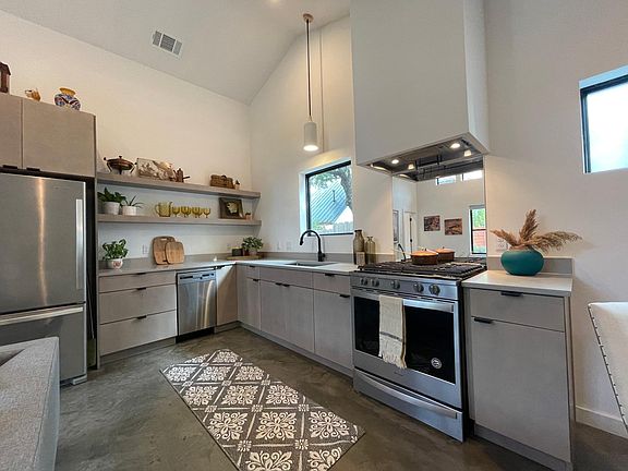 kitchen with new stainless steel appliances , quartz countertops and vaulted ceilings