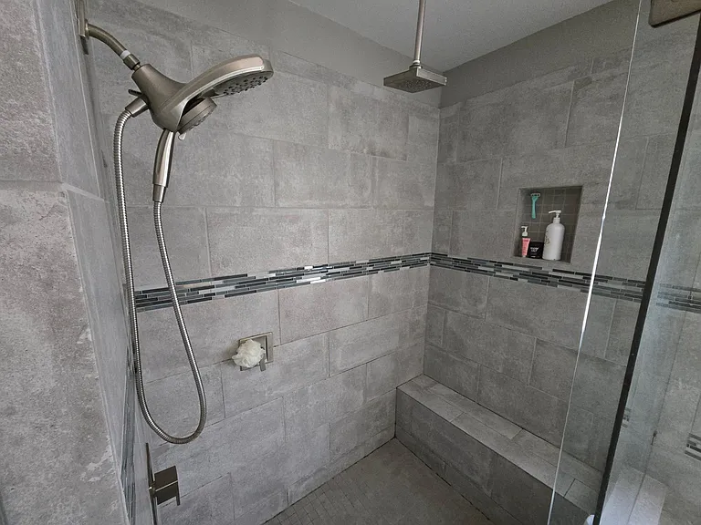 Primary private walk-in shower. Bench seat, 2 separate shower heads (regular handheld and a rain shower head)